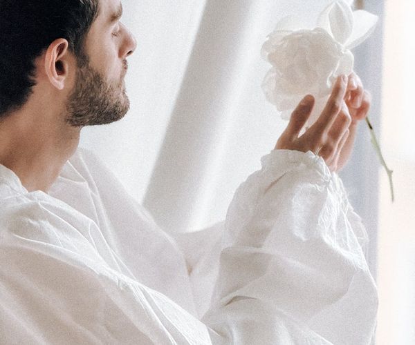 Person stretching gently near a window with soft morning light.