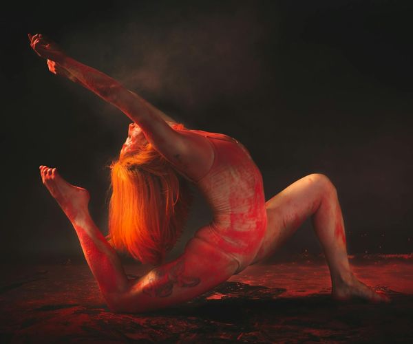 Silhouette of a person performing a graceful dynamic stretch at sunrise.