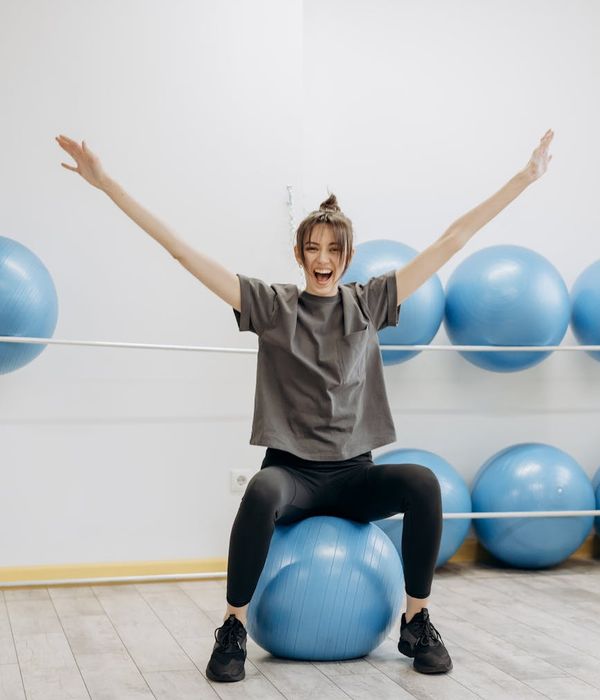 Smiling woman in activewear feeling energetic and balanced in a bright room.